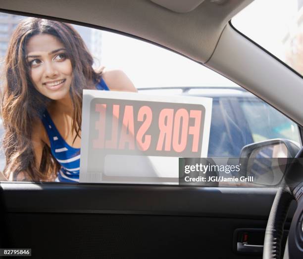 middle eastern woman looking at car for sale - car sale stockfoto's en -beelden