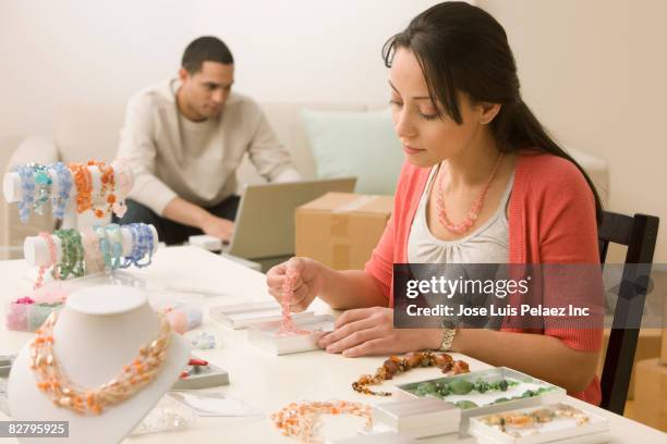 puerto rican woman making jewelry at home - hacer cuentas fotografías e imágenes de stock