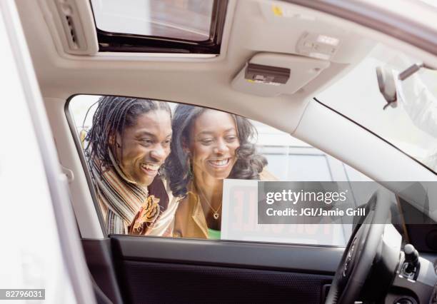 african couple looking at car for sale - car sale stockfoto's en -beelden