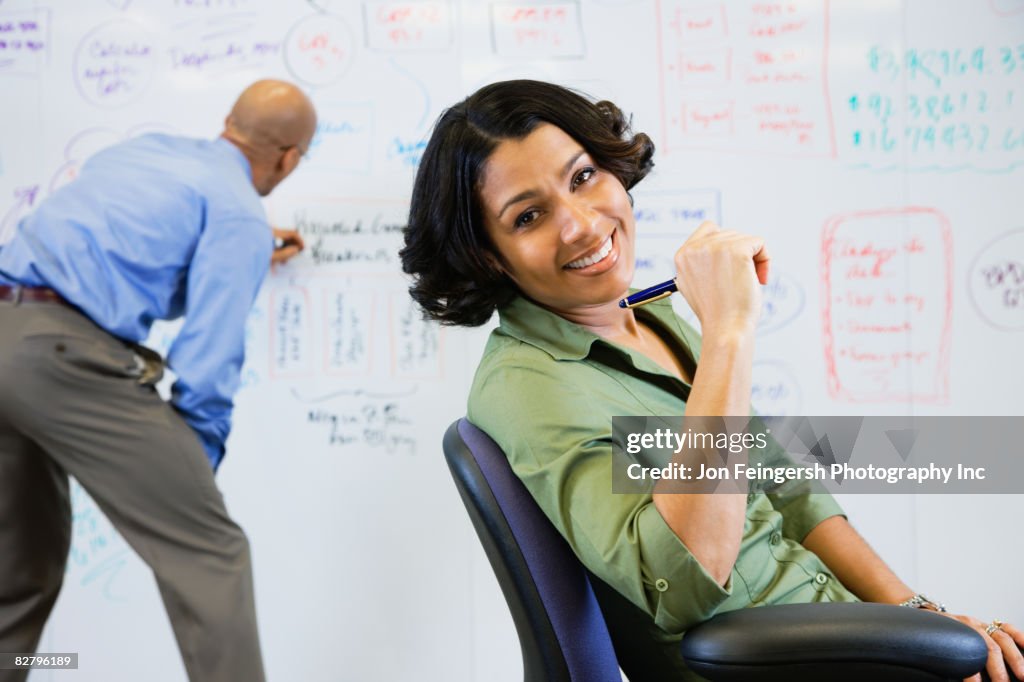 Multi-ethnic business people working on whiteboard 