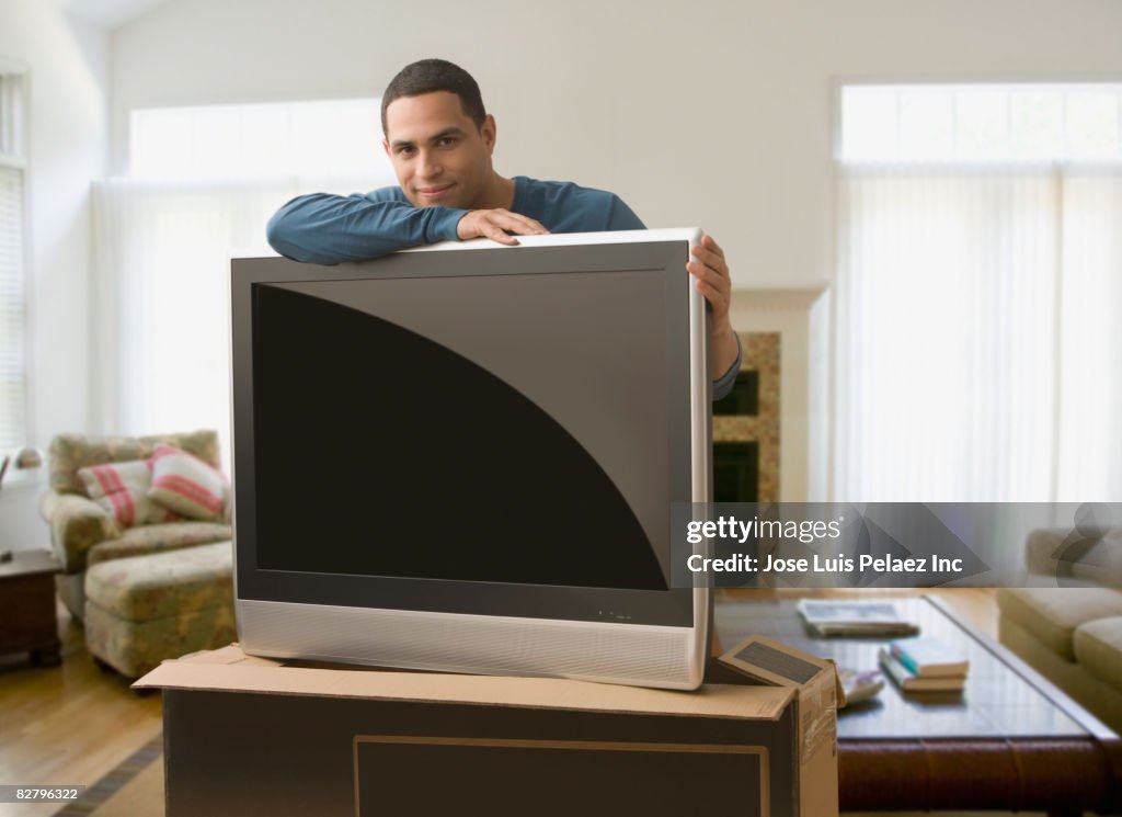 Hispanic man leaning on new television