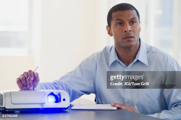 african man working slide projector - slide projector stock pictures, royalty-free photos & images