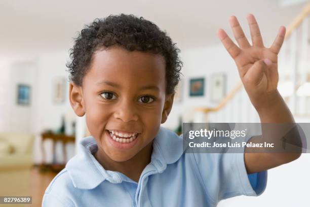 close up of african boy holding up four fingers - quarta feira foto e immagini stock