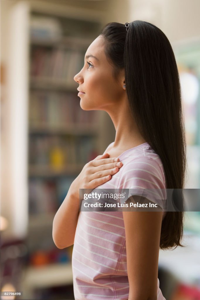 Hispanic girl with hand on heart