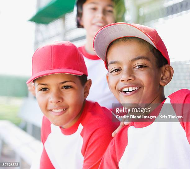 multi-ethnic boys in baseball uniforms smiling - baseball player headshot stock-fotos und bilder