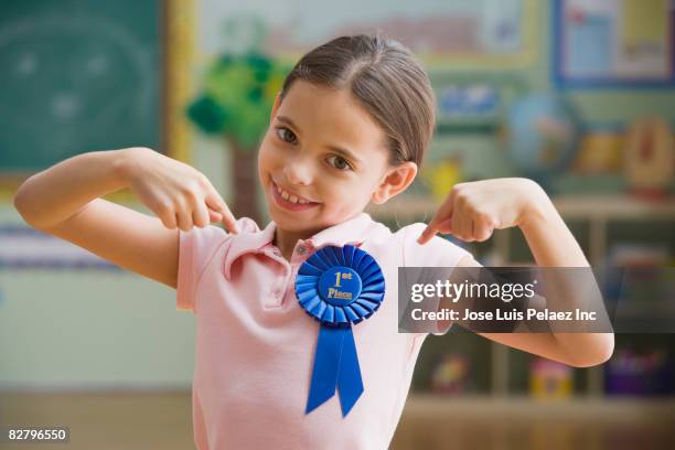 hispanic girl wearing first place ribbon - awards inside stockfoto's en -beelden