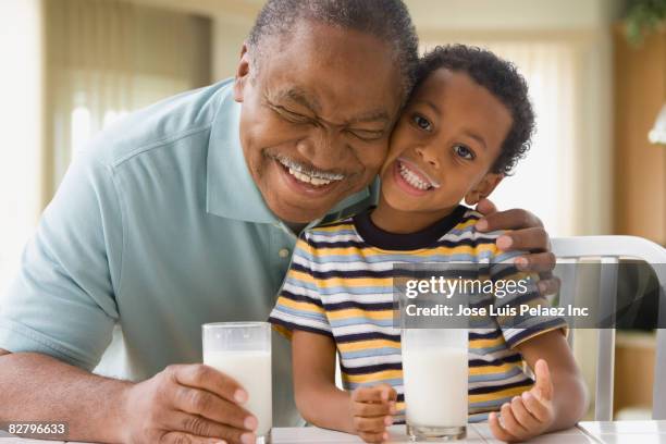 african grandfather and grandson with milk mustaches - milk family stock pictures, royalty-free photos & images