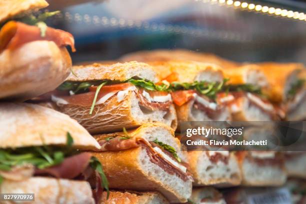 panini made of arugula, tomato and prosciutto crudo - deli stockfoto's en -beelden