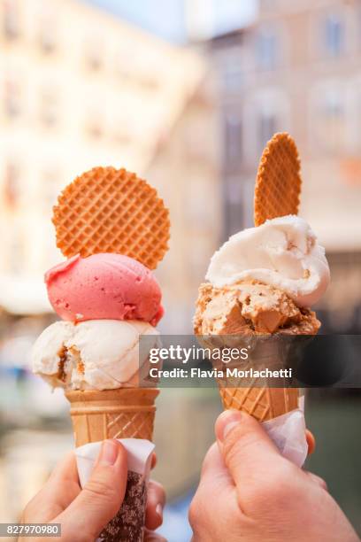 hands holding 'gelatos' in venice - gelato stock-fotos und bilder