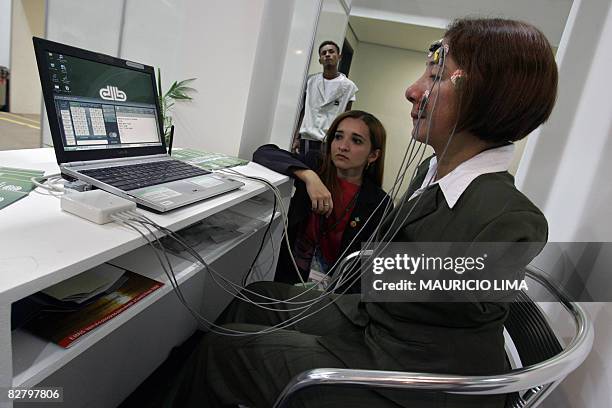 Brazilian armless Maria do Socorro Ferreira types a message on the screen of a laptop through cables connected to her face using an "ocular mouse",...