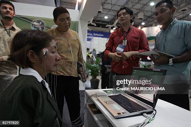 Brazilian armless Maria do Socorro Ferreira types a message on the screen of a laptop through cables connected to her face using an "ocular mouse",...