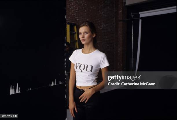 British Supermodel Kate Moss, wearing a t-shirt printed with the word "You" enjoys a quiet moment during a fashion shoot at a photo studio in 1995 in...