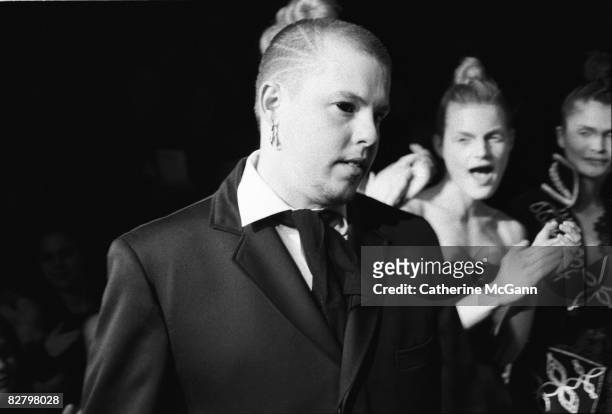 British fashion designer Alexander McQueen with unidentified models in the background at a show of his fashions in March 1996 in New York City, New...