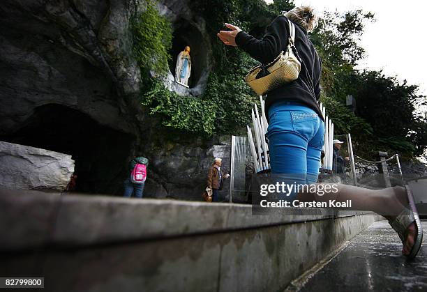 Woman prays beside the Statue of Our Lady of Lourdes at the entrance to the Grotto of Massabielle on September 12, 2008 in Lourdes, France. Pope...