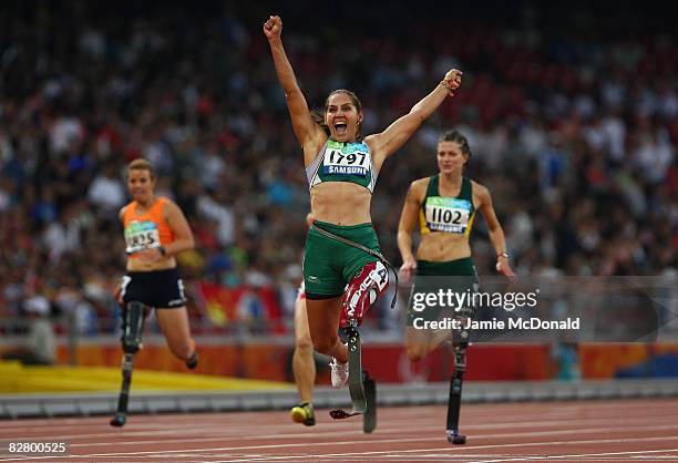 Perla Bustamante of Mexico celebrates winning gold in the Women's 100m -T42 in the Athletics event at the National Stadium during day seven of the...