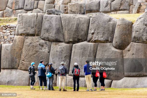 tourist in front of huge stone wall at saqsaywaman, peru - ogphoto stock pictures, royalty-free photos & images