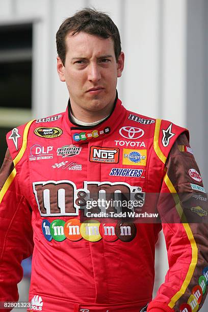 Kyle Busch, driver of the M&M's Toyota, waits in the garage after practice for the NASCAR Sprint Cup Series Sylvania 300 at New Hampshire Motor...