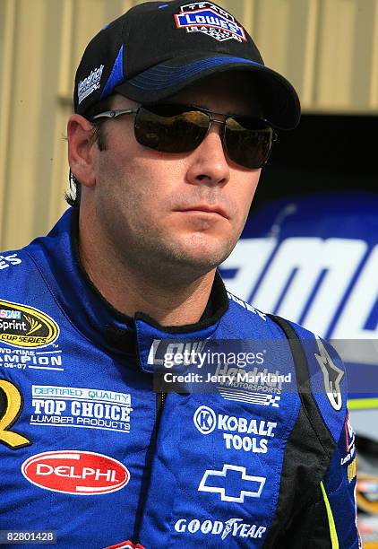 Jimmie Johnson, driver of the Lowe's Chevrolet, stands outside of his garage during practice for the NASCAR Sprint Cup Series Sylvania 300 at New...