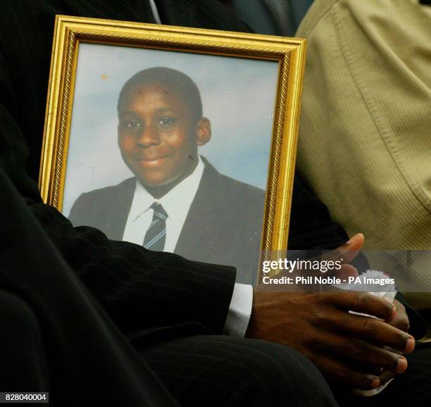 Pastor Daniel from the church which murdered teenager Andrew Walker attended, holds a portrait of the 18-year-old during a vigil in Liverpool city...