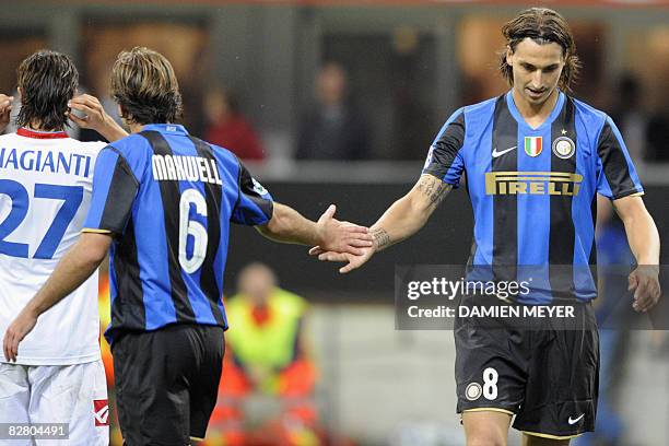 Inter Milan's Swedish forward Zlatan Ibrahimovic shakes hands with Brazilian teammate defender Maxwell during their Italian Serie A football match at...