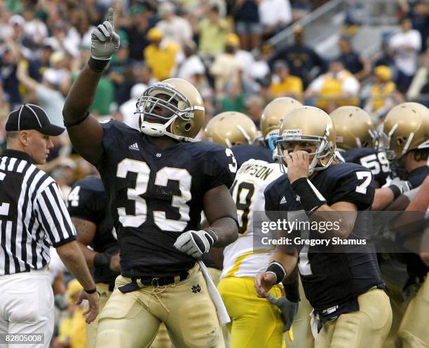 Robert Hughes of the Notre Dame Fighting Irish celebrates a second quarter touchdown in front of Jimmy Clausen while playing the Michigan Wolverines...