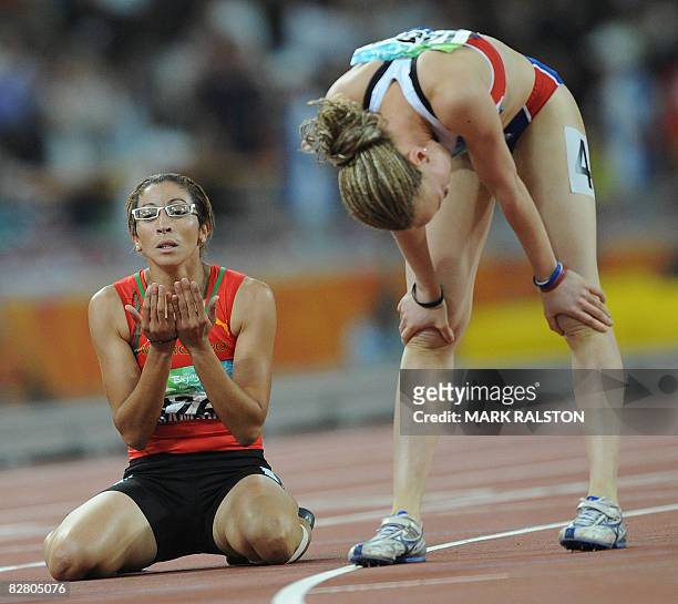 Sanaa Benhama of Morocco prays beside Nantenin Keita of France after winning the final of the women's 400 metre T13 classification event at the 2008...