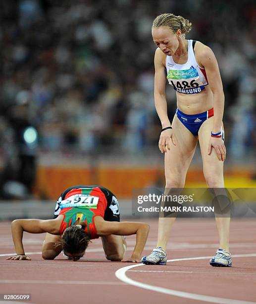 Sanaa Benhama of Morocco prays beside Nantenin Keita of France after winning the final of the women's 400 metre T13 classification event at the 2008...