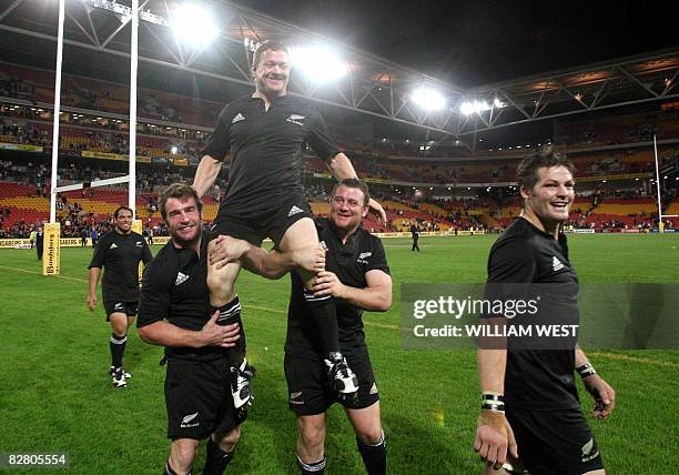 New Zealand All Blacks player Greg Somerville is carried off the field by Tony Woodcock and Andrew Hore as captain Richie McCaw looks on after...