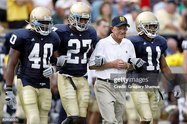 Former head coach Lou Holtz of the Notre Dame Fighting Irish walks out for the coin toss with David Grimes, David Bruton and Maurice Crum prior to...