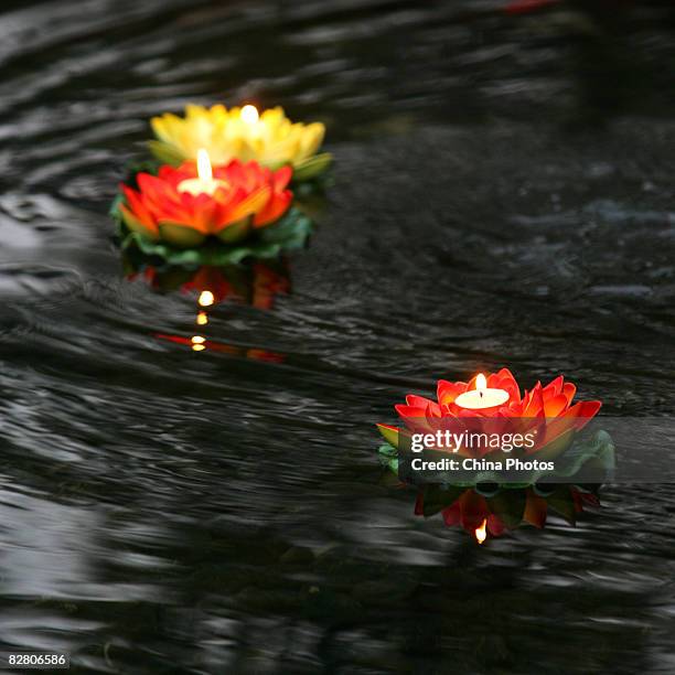 People float candle lights to pray for good luck during an evening to mark the Mid-Autumn Festival on September 13, 2008 in Xian of Shaanxi Province,...