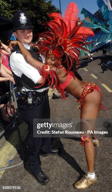 Reveller from Trinidad dances with a reluctant policeman at the Notting Hill Carnival in west London, Monday August 29, 2005. The streets of Notting...