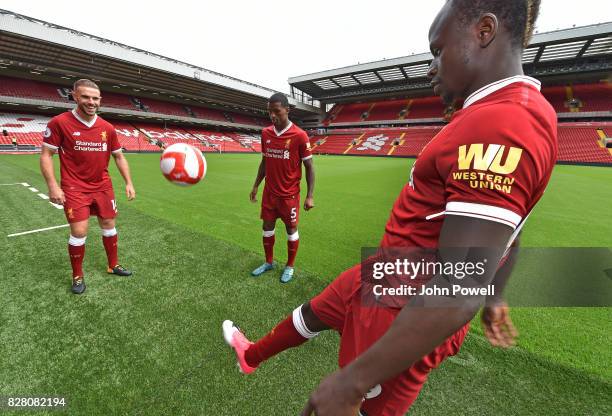 For the Launch of the Western Union partnership Sadio Mane, Jordan Henderson and Georginio Wijnaldum of Liverpool wear the shirts with the logo on...