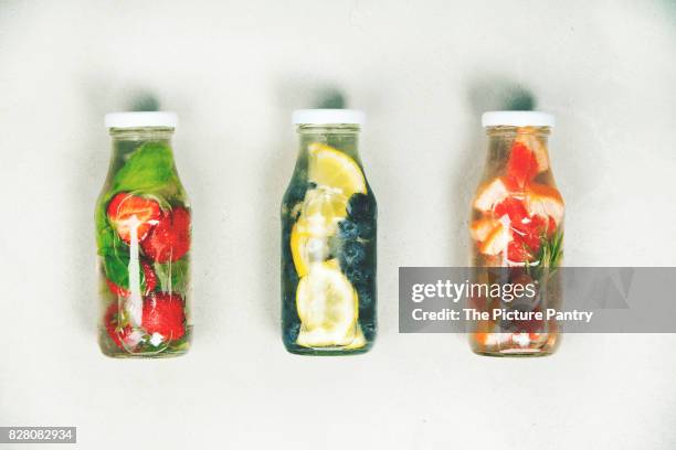 detox fruit infused flavored water. refreshing summer homemade cocktail on grey background. top view - alcohol detox foto e immagini stock