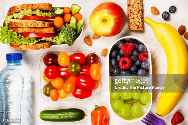healthy lunch box with sandwich and fresh vegetables, bottle of water and fruits on wooden background. top view - packed lunch - fotografias e filmes do acervo