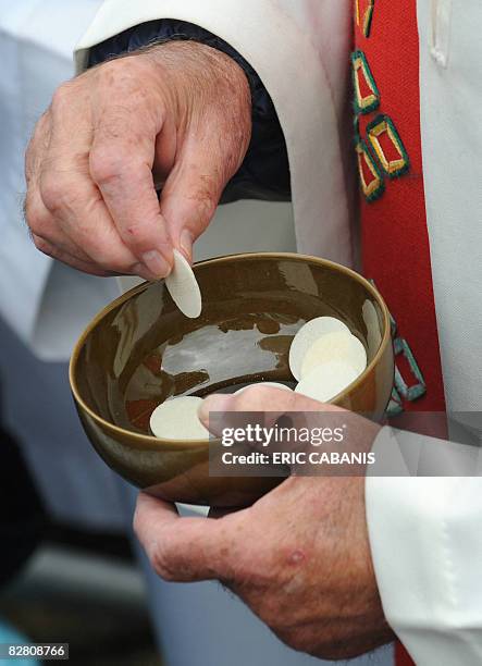 Priests holds communion wafers after Pope Benedict XVI celebrated mass at La Prairie in Lourdes on September 14, 2008 in celebration of the 150th...