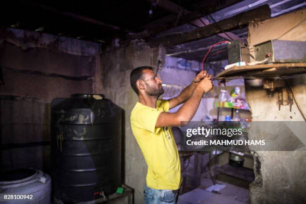 Palesstinian man charges a car battery during the few hours of mains electricity supply the residents of the Gaza Strip receive every day, in Gaza...