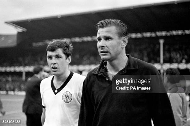 West Germany's Lothar Emmerich leaves the pitch with USSR goalkeeper Lev Yashin after the match