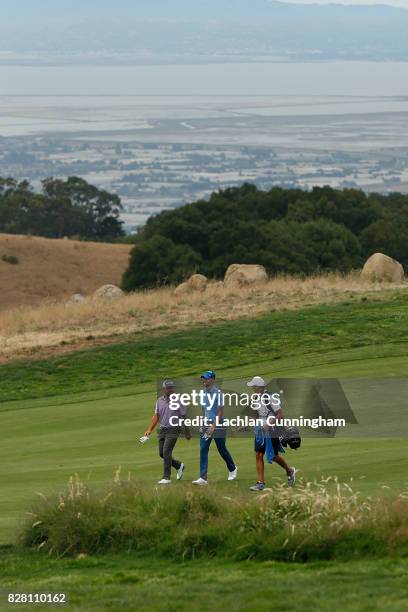 Stephen Curry walks the eighteenth fairway with playing partner Stephan Jaeger of Germany and Curry's caddie Jonnie West during round one of the...