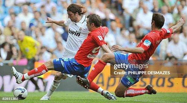 Real Madrid's Gonzalo Higuain tries to kick past Numancia's Sergio Boris and Cesar Palacios during the Spanish league football match Real...