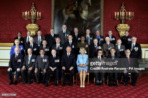 The Prince of Wales and the Duchess of Cornwall sit for a group photo with the surviving members of the Victoria Cross and George Cross association...