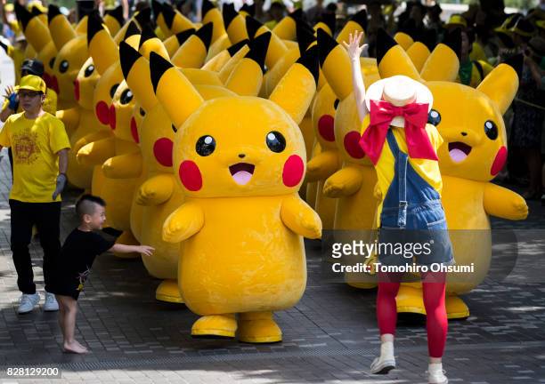 Performers dressed as Pikachu, a character from Pokemon series game titles, march during the Pikachu Outbreak event hosted by The Pokemon Co. On...