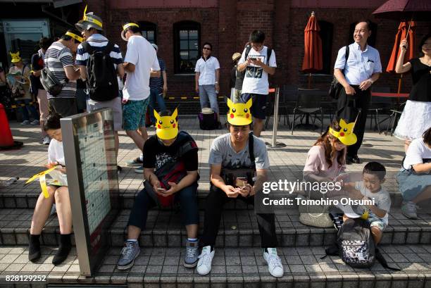 People play Nintendo Co.'s Pokemon Go augmented reality game on their smartphones during the Pikachu Outbreak event hosted by The Pokemon Co. On...