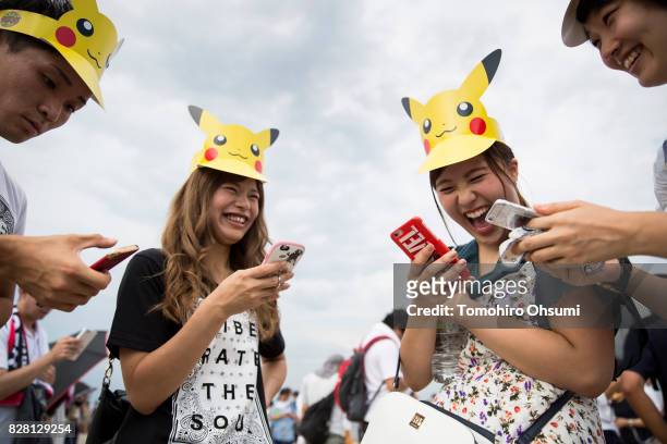 People play Nintendo Co.'s Pokemon Go augmented reality game on their smartphones during the Pikachu Outbreak event hosted by The Pokemon Co. On...