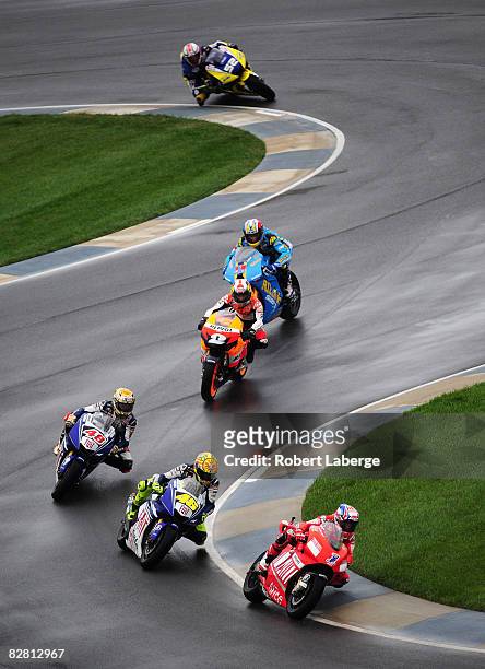 Casey Stoner of Australia rides the Ducati ahead of Valentino Rossi and a group of riders during the MotoGP Red Bull Indianapolis Grand Prix at the...