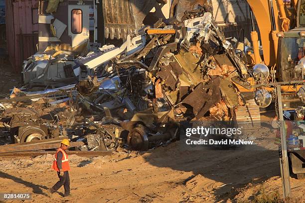 Workers remove the remains of a Metrolink commuter train on September 14, 2008 in Chatsworth, California. The Metrolink commuter train was involved...