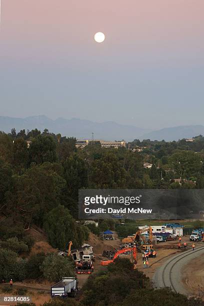 Workers remove the remains of a Metrolink commuter train on September 14, 2008 in Chatsworth, California. The Metrolink commuter train was involved...