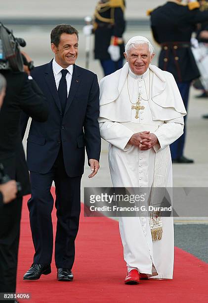 Pope Benedict XVI walks on red carpet beside French President Nicolas Sarkozy as he arrives at Orly airport on September 12, 2008 in Paris, France....