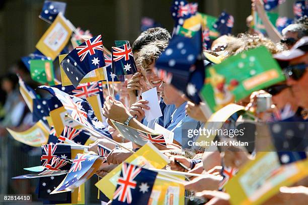 Fans wave flags along the route during a welcome home parade for the Beijing 2008 Olympic Athletes on George Street on September 15, 2008 in Sydney,...