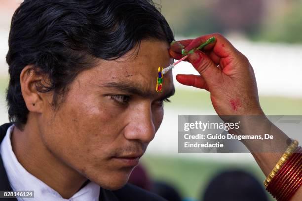 a hindu man receives a tika on his forehead during bhai tika (tihar, diwali) celebrations in kathmandu, nepal. - bhai phonta stock pictures, royalty-free photos & images