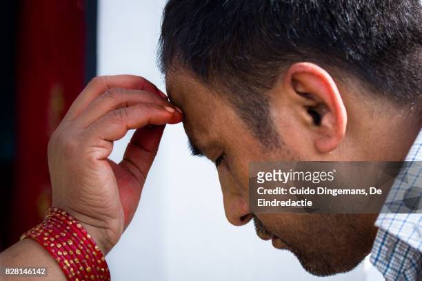 a hindu man receives a tika on his forehead during bhai tika (tihar, diwali) celebrations in kathmandu, nepal. - bhai phonta stock pictures, royalty-free photos & images